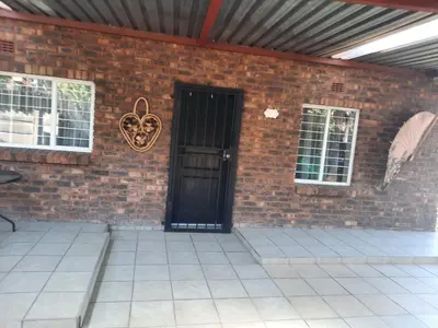 a brick wall with a black door on a building at Legaeng Cottage - Serenity in Pretoria