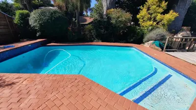 a swimming pool in a yard with a brick patio at Legaeng Cottage - Serenity in Pretoria