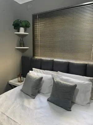 a bedroom with a bed with white sheets and pillows at Solace Unit in Phalaborwa