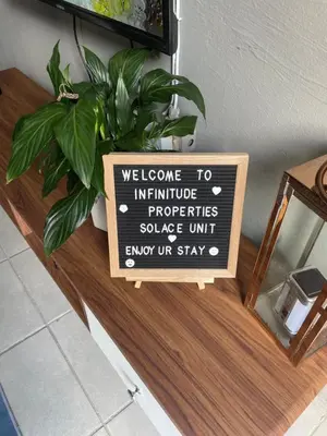 a sign on a table with a plant on it at Solace Unit in Phalaborwa