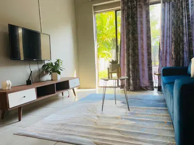 a living room with a tv and a blue couch at Solace Unit in Phalaborwa