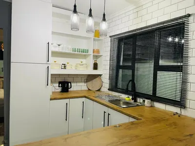 a kitchen with white cabinets and a sink and a window at Solace Unit in Phalaborwa