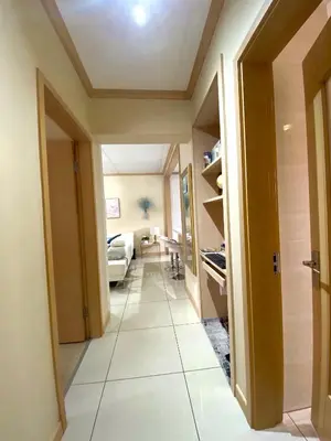 a hallway with a large tile floor and a living room at Siena Sun Luxury Suite 1 in Midrand