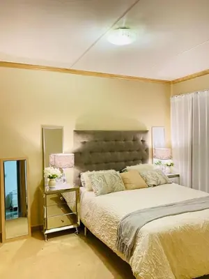 a bedroom with a large bed and a mirror at Siena Sun Luxury Suite 1 in Midrand