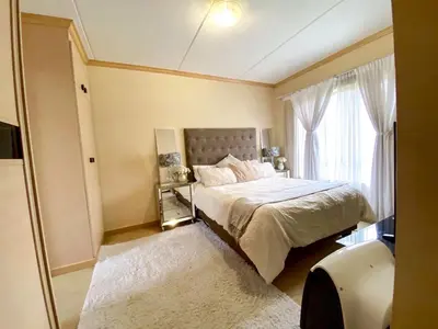 a bedroom with a bed and a large window at Siena Sun Luxury Suite 1 in Midrand