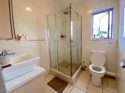 a bathroom with a shower and a toilet and a sink at Siena Sun Luxury Suite 1 in Midrand