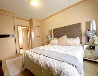a bedroom with a large bed with a large headboard at Siena Sun Luxury Suite 1 in Midrand