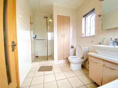a bathroom with a shower and a toilet and a sink at Siena Sun Luxury Suite 1 in Midrand