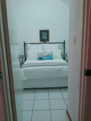 a bedroom with a white bed with a head board at Unit 24 Pendleberry Grove Holidays in Bela-Bela