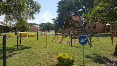 a playground with a swing set in a park at Unit 24 Pendleberry Grove Holidays in Bela-Bela