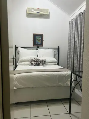 a bedroom with a large bed with a radiator at Unit 24 Pendleberry Grove Holidays in Bela-Bela