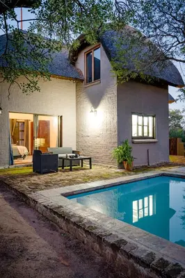 a house with a swimming pool in front of it at Nkanyi Wildlife House & Cottage in Hoedspruit