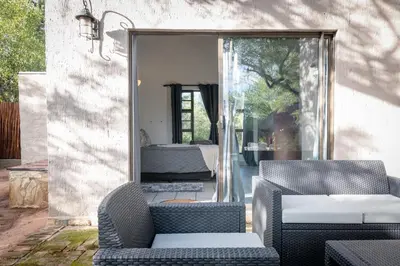 a patio with two chairs and a couch at Nkanyi Wildlife House & Cottage in Hoedspruit