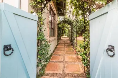 an alleyway with a blue gate and a building at Ambiance Guesthouse in Pretoria