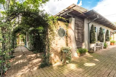 a house with an archway and vines on it at Ambiance Guesthouse in Pretoria