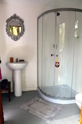 a bathroom with a glass shower and a sink at Ndlovu Tiny Home with a hot tub in Dinokeng in Klipdrift