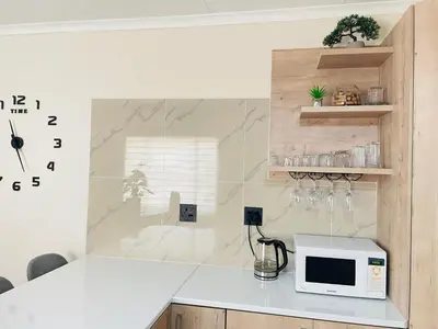 a kitchen with a microwave on a counter at Mnqobi Lifestyle Apartments in Nelspruit