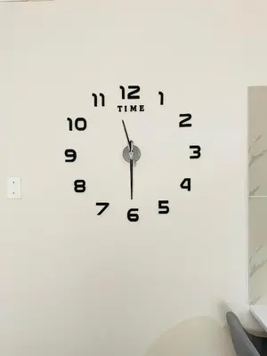 a clock on a white wall with black numbers at Mnqobi Lifestyle Apartments in Nelspruit