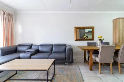 a living room with a blue couch and a table at The blyde lovely 1 bedroom in Pretoria