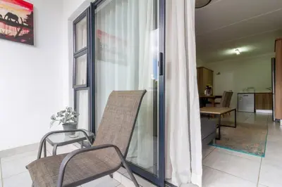 a living room with a chair and a table at The blyde lovely 1 bedroom in Pretoria