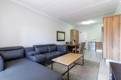 a living room with a blue couch and a table at The blyde lovely 1 bedroom in Pretoria