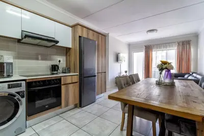 a kitchen with a wooden table and a dining room at The blyde lovely 1 bedroom in Pretoria