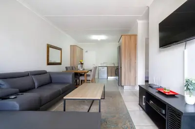 a living room with a couch and a table at The blyde lovely 1 bedroom in Pretoria