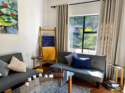 a living room with two couches and a window at The White House in Hartbeespoort