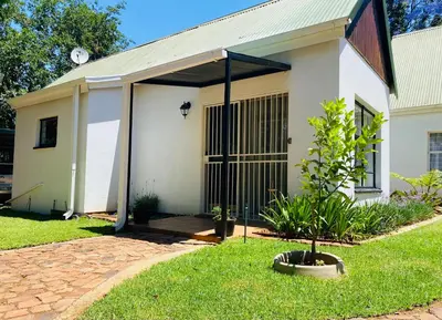 a small white house with a garage at The White House in Hartbeespoort