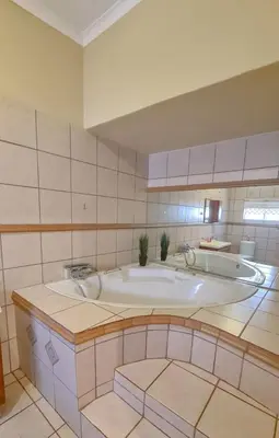 a bathroom with a large tub in a room at Alpha B Lodging in Thabazimbi