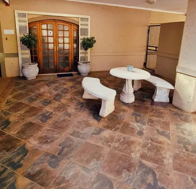 a room with a table and a table and benches at Alpha B Lodging in Thabazimbi