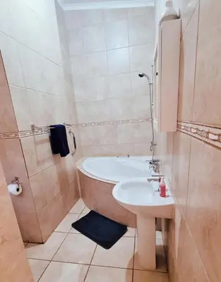 a bathroom with a bath tub and a sink at Alpha B Lodging in Thabazimbi