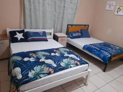 a bedroom with two beds with blue and white sheets at Cozy guesthouse springs in Springs