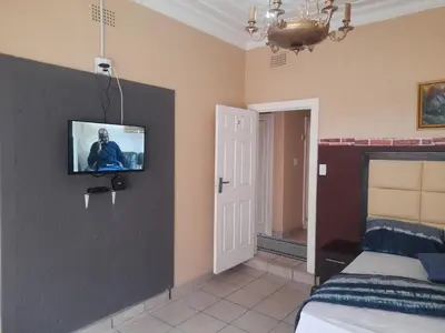 a bedroom with a bed and a tv on the wall at Cozy guesthouse springs in Springs