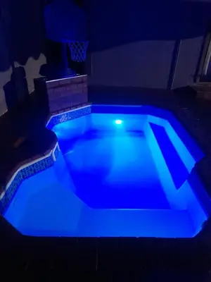a blue swimming pool in a dark room at Cozy guesthouse springs in Springs