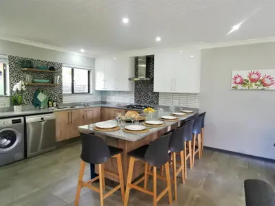 a kitchen with a large wooden table and chairs at The Bird Hide Luxury Self catering Chalets in White River