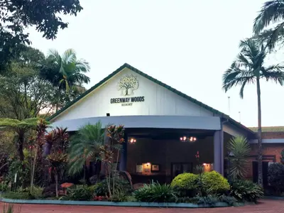 a front view of a building with palm trees at The Bird Hide Luxury Self catering Chalets in White River