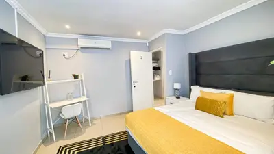 a bedroom with a large bed with a yellow blanket at Midrand Air B and B House in Midrand
