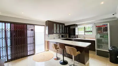 a kitchen with a counter and some chairs in it at Midrand Air B and B House in Midrand