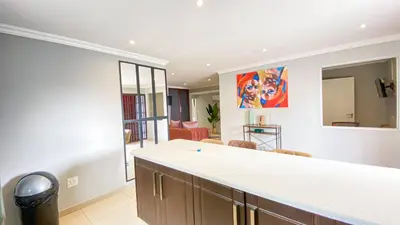a kitchen with a counter and a living room at Midrand Air B and B House in Midrand
