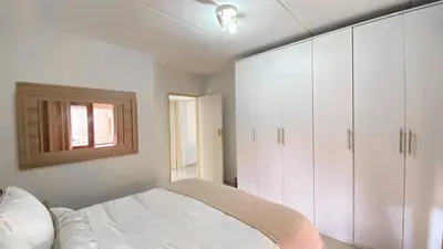 a bedroom with white cabinets and a bed at Midrand Air B and B Apartment in Midrand