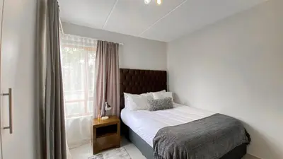 a small bedroom with a bed and a window at Midrand Air B and B Apartment in Midrand
