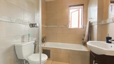 a bathroom with a toilet and a tub and a sink at Midrand Air B and B Apartment in Midrand