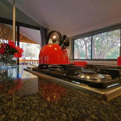 a kitchen with a red tea kettle on a stove at Cosy Corner in Kampersrus AH
