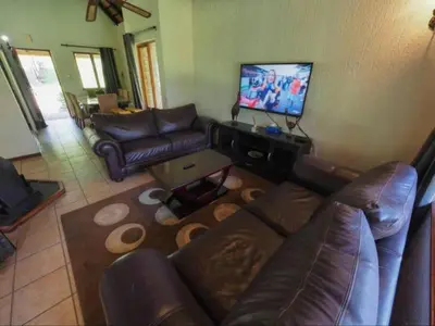 a living room with a couch and a flat screen tv at Kruger Park Lodge Unit 550 With Private Pool in Hazyview
