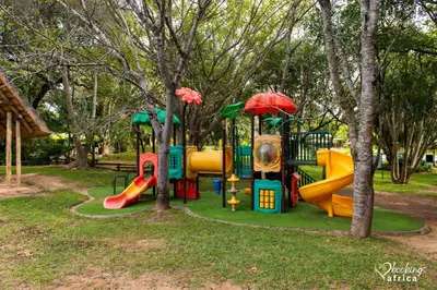 a park with a playground with slides and trees at Kruger Park Lodge Unit 550 With Private Pool in Hazyview