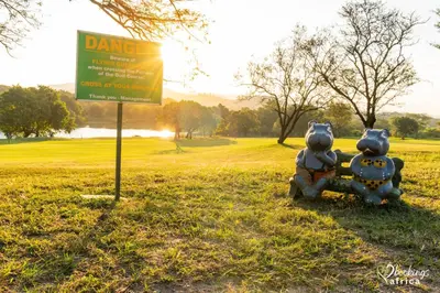 two teddy bears sitting next to a sign in a field at Kruger Park Lodge Unit 550 With Private Pool in Hazyview