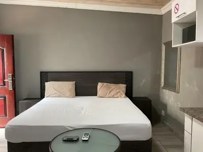 a bedroom with a large bed with a table at northmead lodge in Benoni