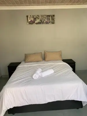 a bed with two rolled up towels on it at northmead lodge in Benoni