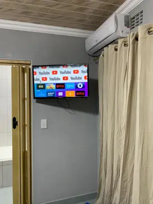 a television hanging on a wall in a room at northmead lodge in Benoni